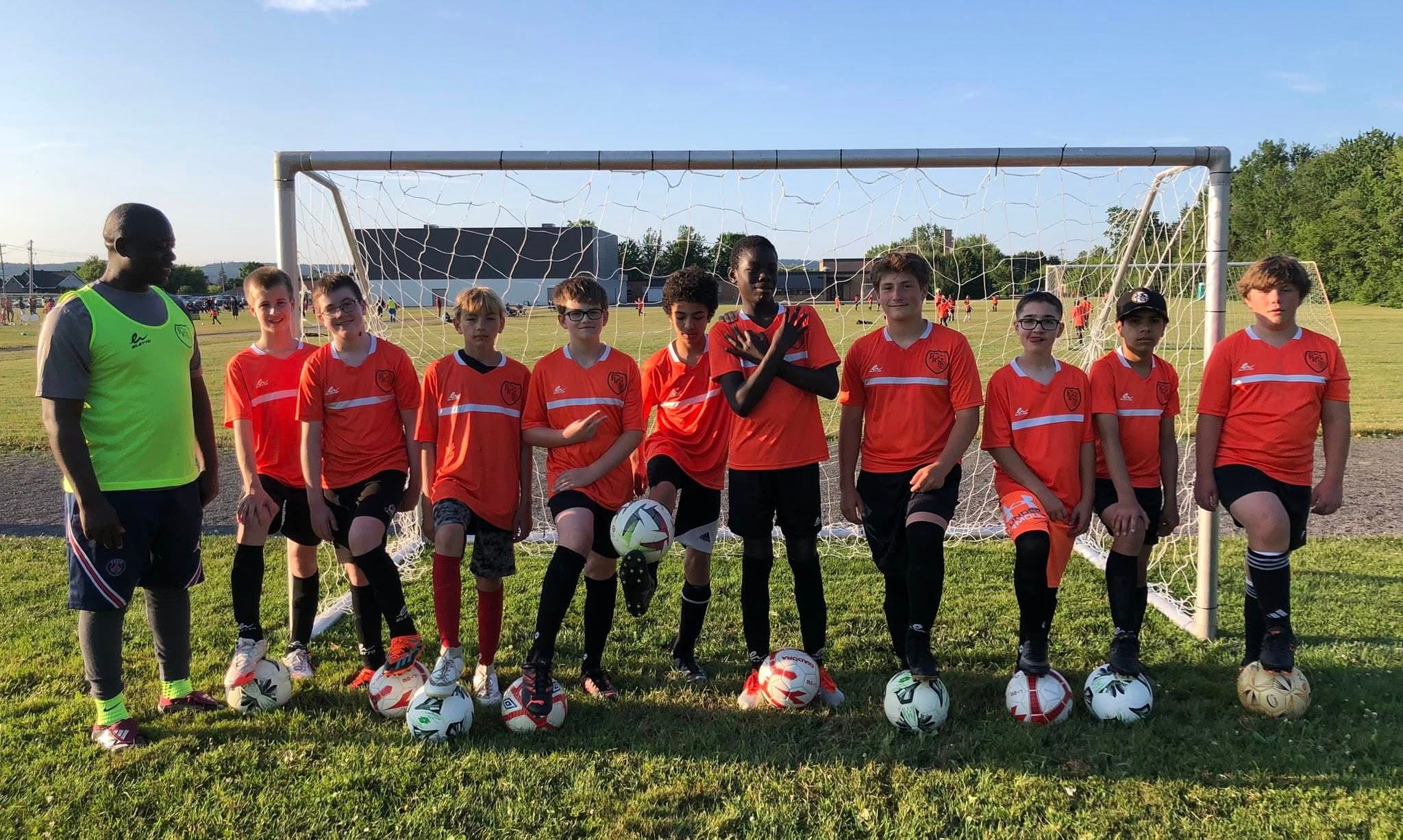 Soccer boys lined up with balls